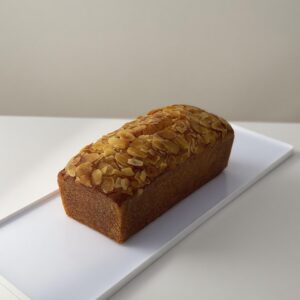 Orange Almond Butter Cake topped with orange zest and almond, sliced to show its moist and tender crumb.